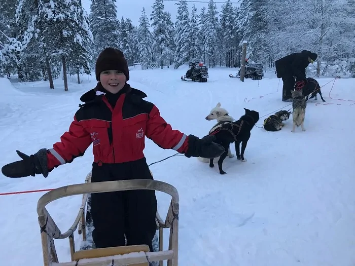 Deborah Bradley-Kramer, MUSE Academy, child, sled, dogs, snow, white, parent, winter, smile, trees, red, coat, outdoors